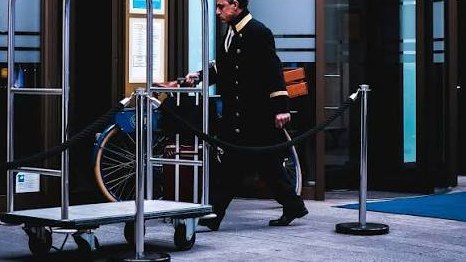 Hotel porter with a luggage trolley